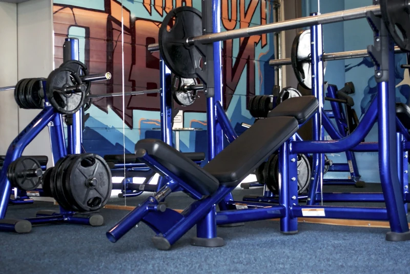Les tapis sportifs pour protection de sol Pro WARCO installés sous les équipements de musculation dans une salle de gym.