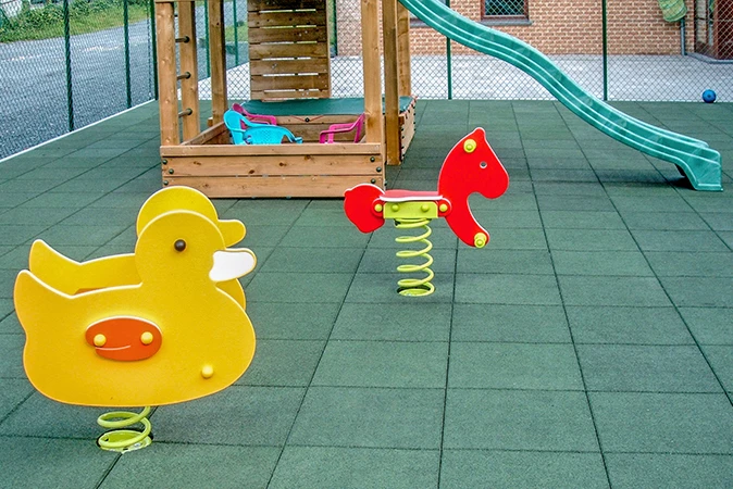 L’aire de jeux pour enfants est équipée de divers équipements de jeux et de dalles de sécurité avec la protection antichute de WARCO.