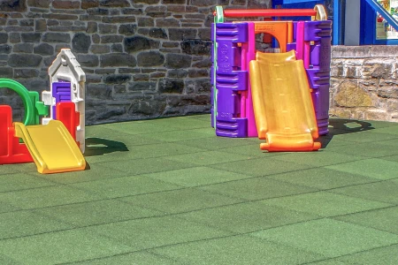 Les dalles antichoc WARCO dans l'aire de jeux pour jeunes enfants offrent une protection contre les chutes et les chocs pendant le jeu.