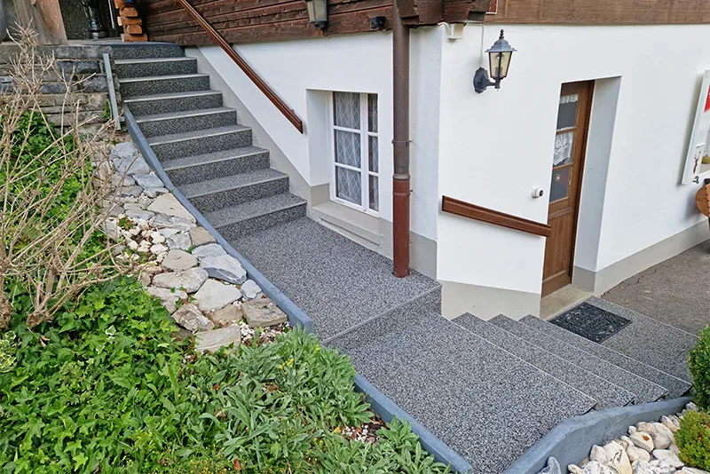 Le revêtement d'escalier antidérapant de WARCO en couleur Granit clair passe directement devant la maison dans les Alpes.