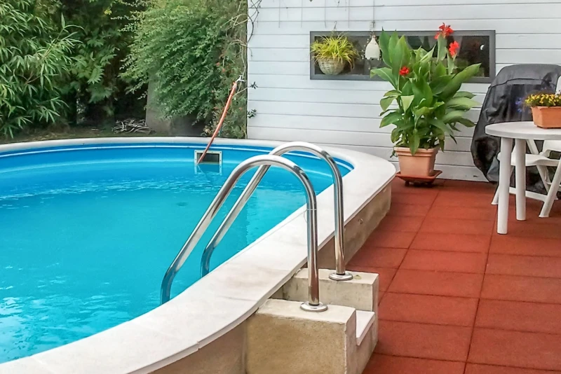 Direkt im Anschluss an die Terrasse ist ein Außenpool im Garten eingebaut. Die wasserdurchlässigen, roten Schwimmbadfliesen sorgen für Sicherheit, trockene Füße und Komfort auf der Terrasse und am Pool.gemauerter Pool mit roten Schwimmbadfliesen