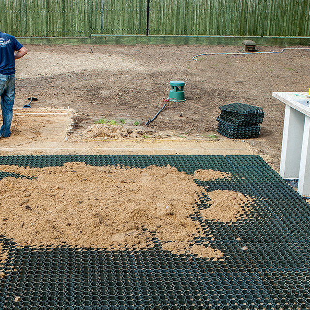 La pose de grilles de stabilisation WARCO en plastique dans le jardin, sur une sous-couche non liée et remplies de sable.
