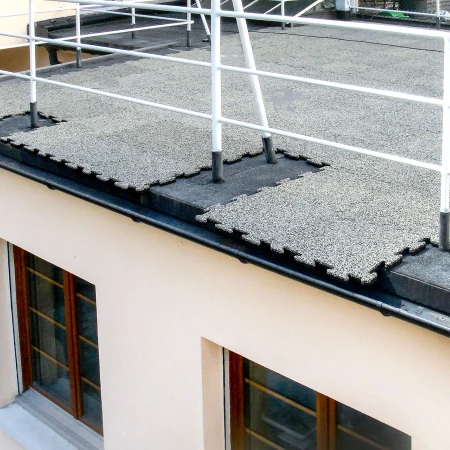 Les dalles WARCO de couleur Granit clair sont posées directement sur le feutre de toiture utilisé pour sceller le toit plat. Les dalles au bord de la terrasse du toit sont coupées sur mesure et posées à l'extrémité.