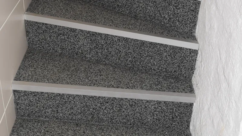 graue Treppe innen nach der Verkleidung . Innebreich gestaltet mit WARCO-Treppenbelag.